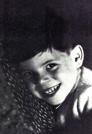 Photo of Peter at five years old. Its a portrait of his face and he is smiling.
