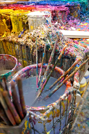 Photo of Peter's pallet and a jar of water filled with paint brushes.