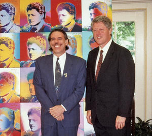 Peter Max standing with President Bill Clinton in front of '100 Clintons' paintings.