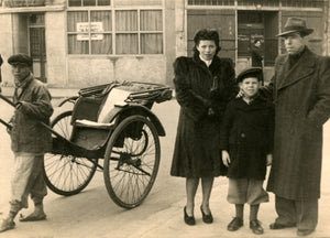 Peter Max as a boy standing next to his parents in China with a carriage next to them.